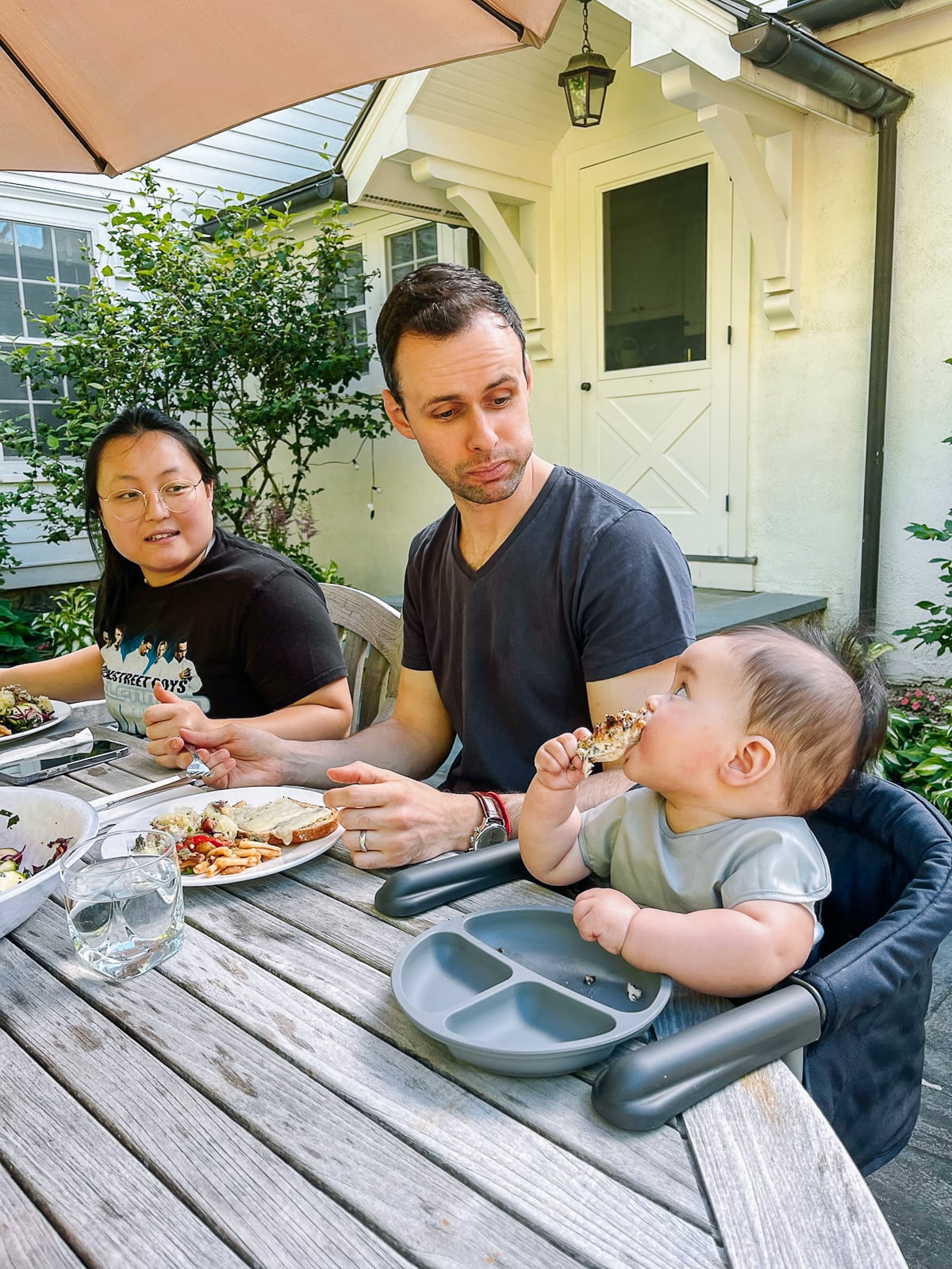 Kaitlin and Justin looking at Ethan eating chicken