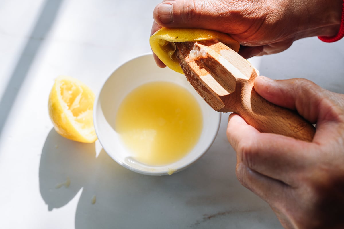 squeezing lemon juice into bowl