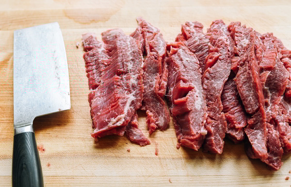 slicing beef flank steak into long thin slices. 