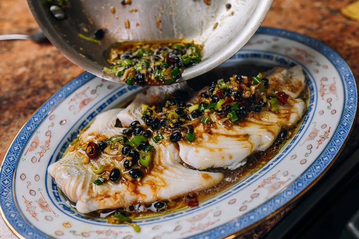 pouring black bean garlic sauce over fish fillet