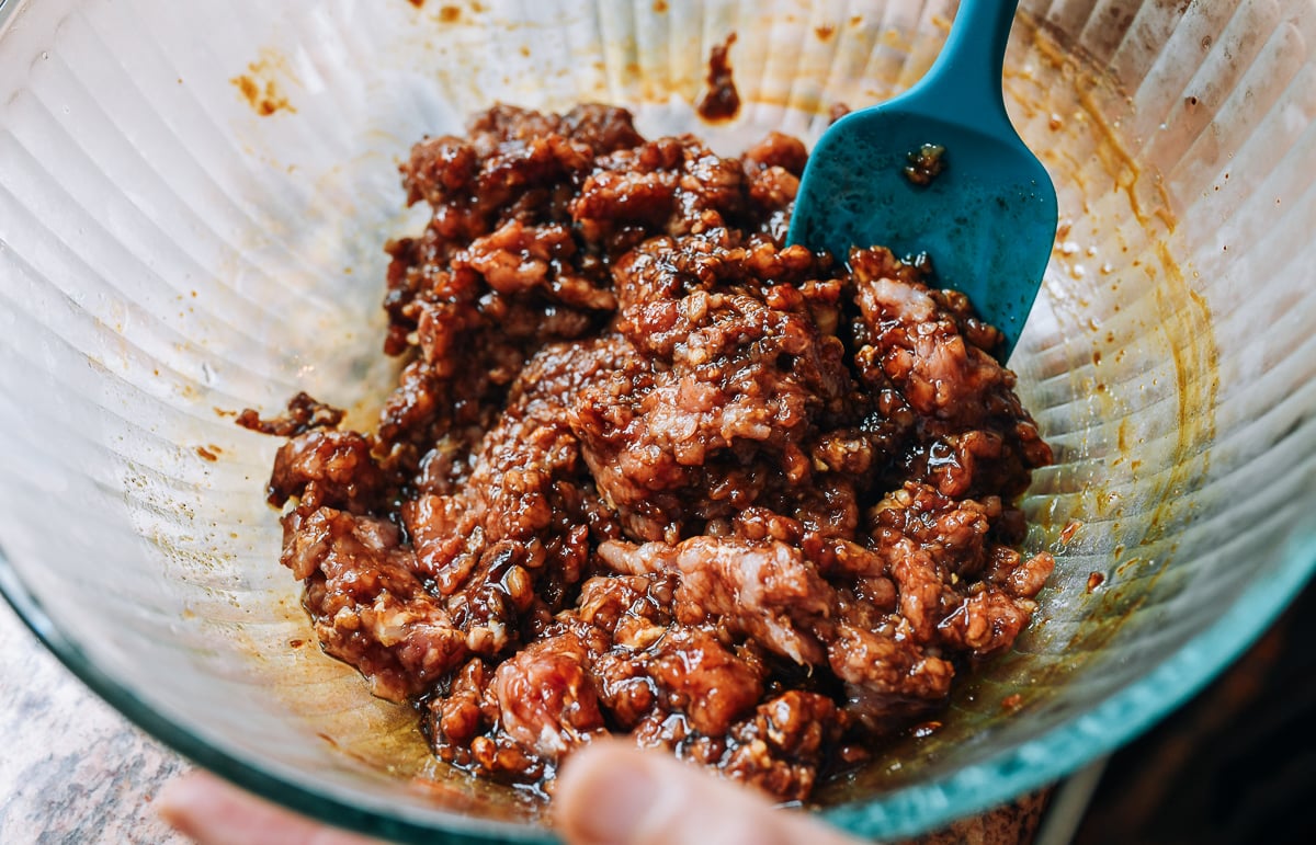 mixing pork with seasoning ingredients