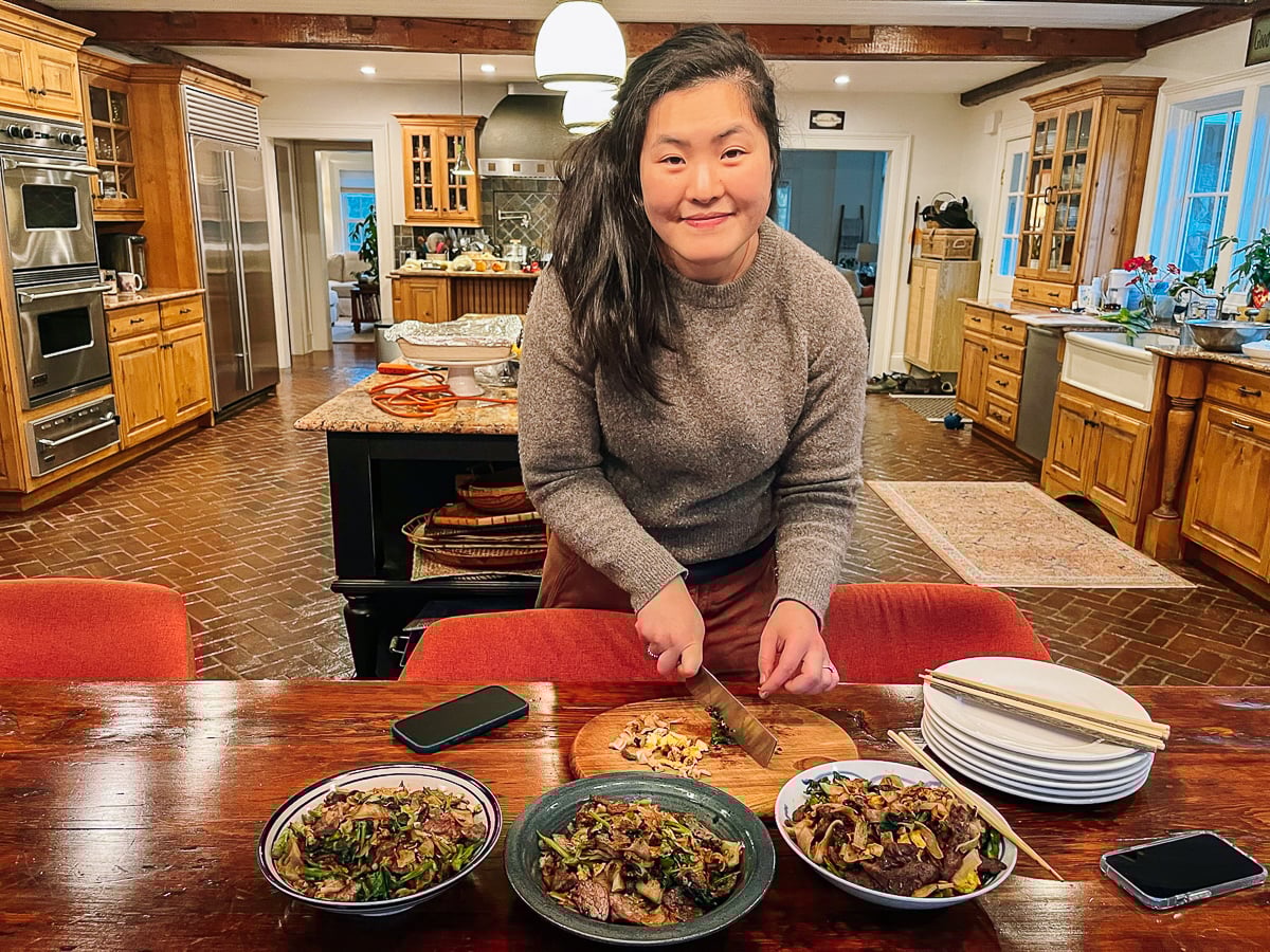 Sarah chopping noodle dish on cutting board