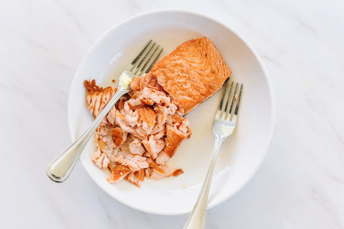 Flaking cooked salmon with two forks