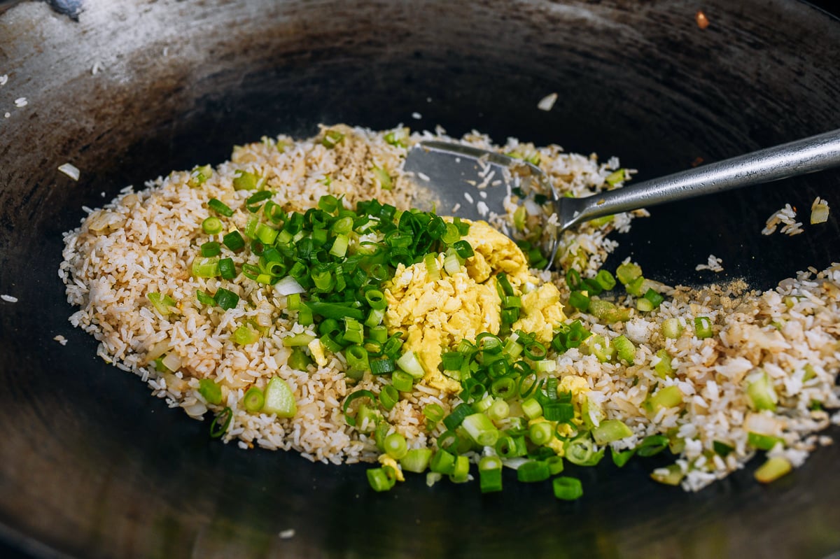 adding scallions and eggs to fried rice