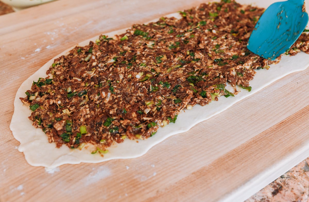 meat filling spread onto dough sheet