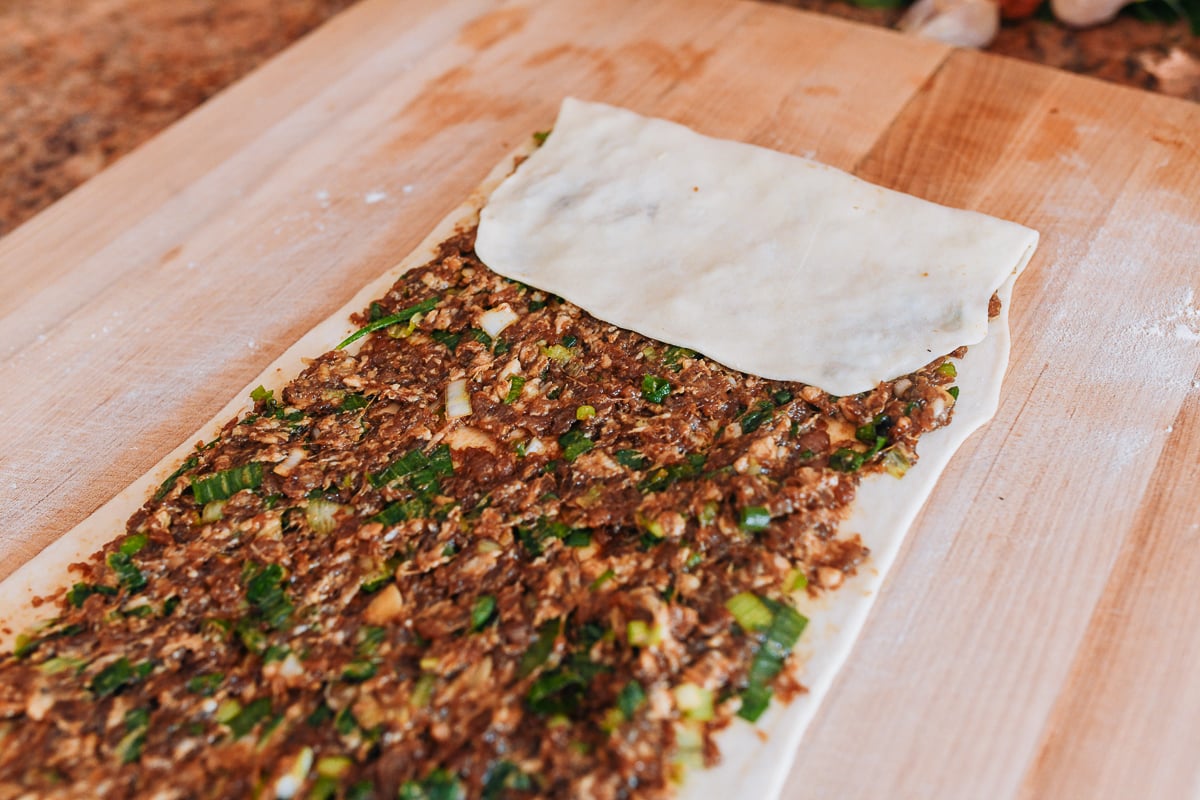 folding meat pie dough with filling onto itself