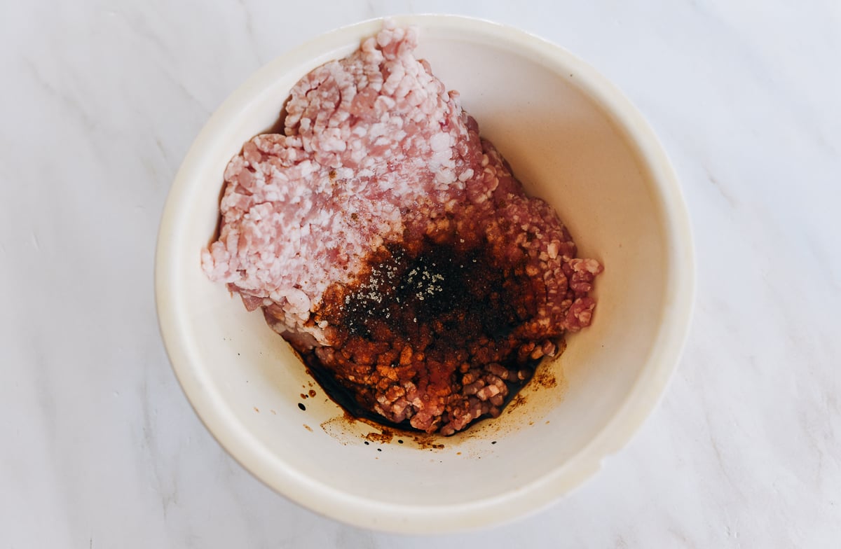 Ground pork in bowl with seasoning