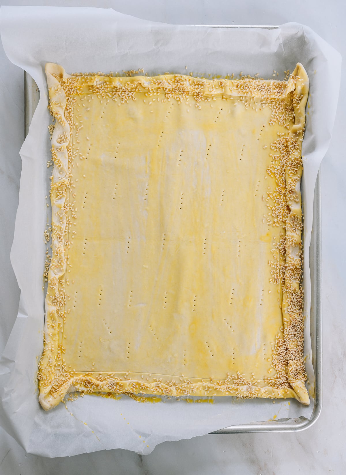 puff pastry crust with crimped edge, egg wash and fork docking