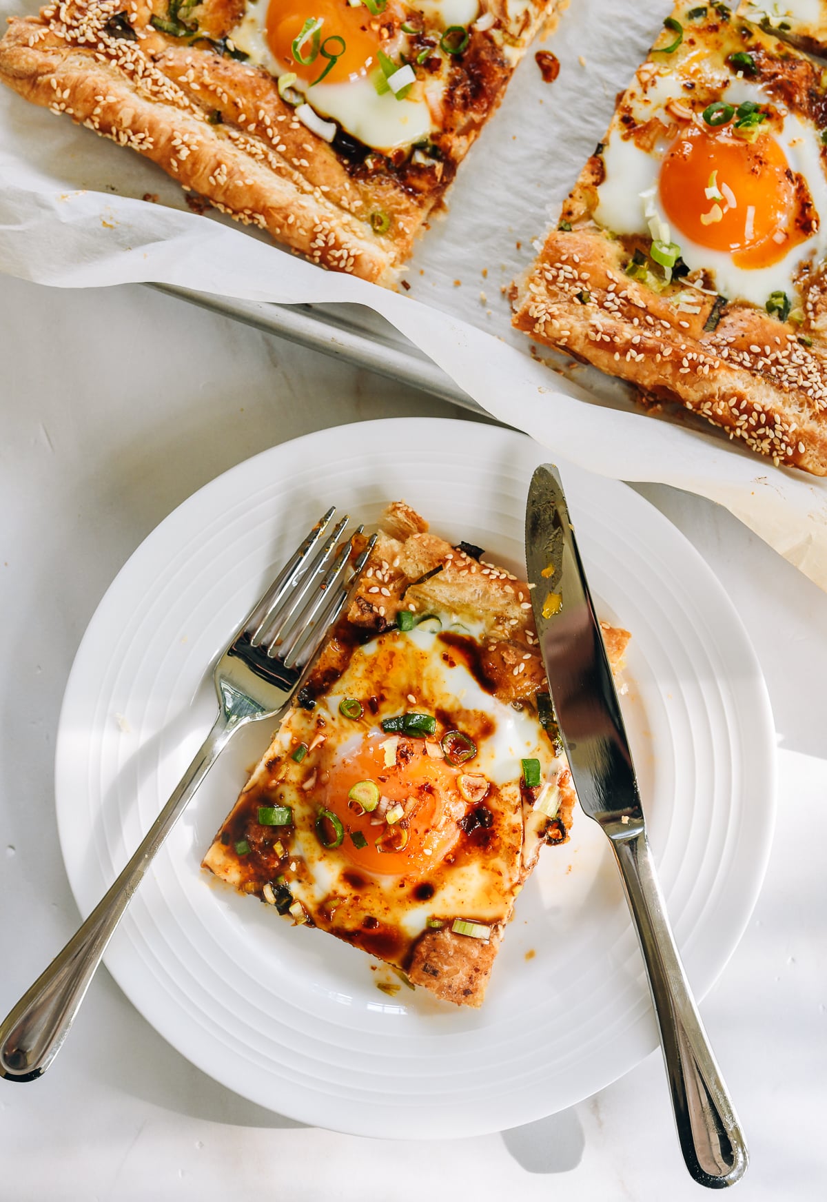 Serving of Egg baked into puff pastry with scallion, soy sauce, and chili oil