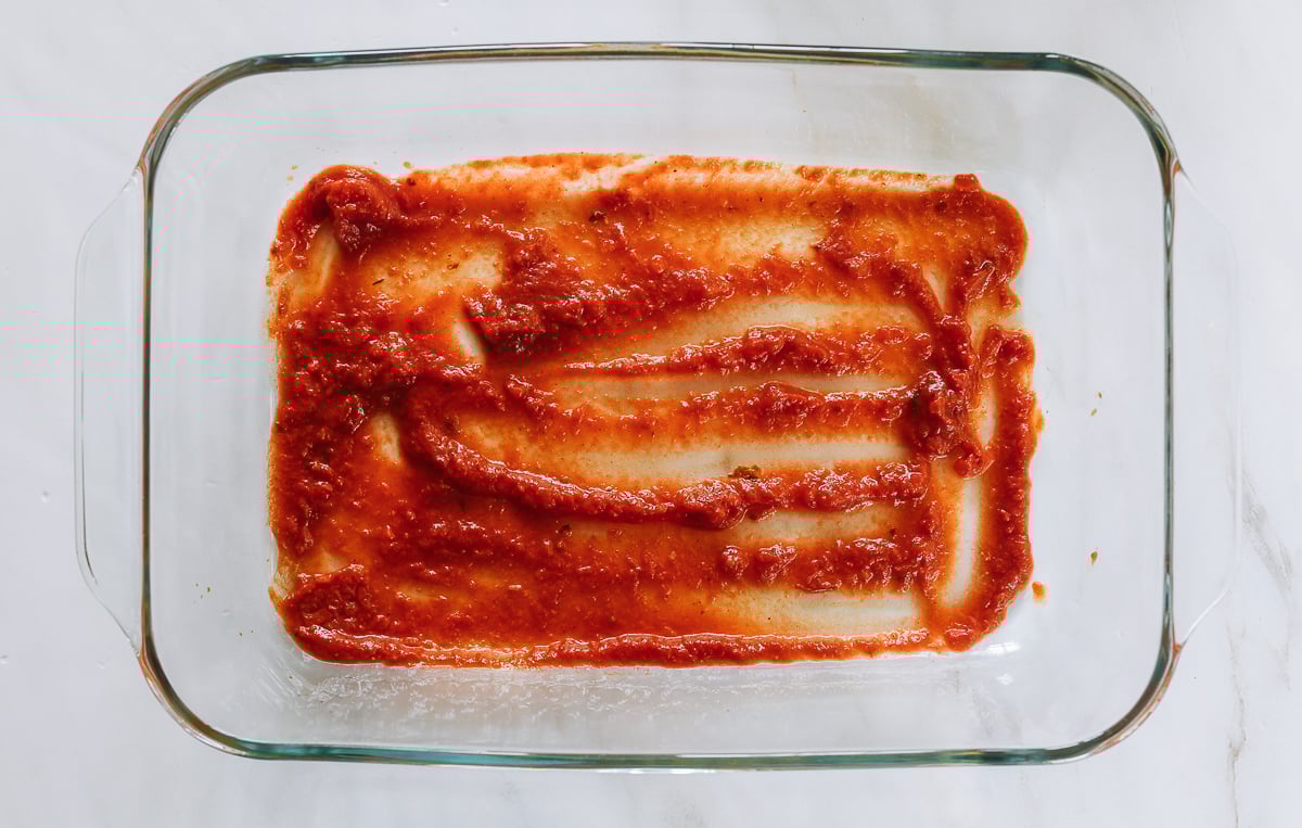 marinara sauce at bottom of 9x13 inch baking dish