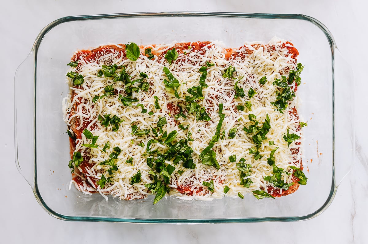 basil sprinkled over cheese, sauce, and bread
