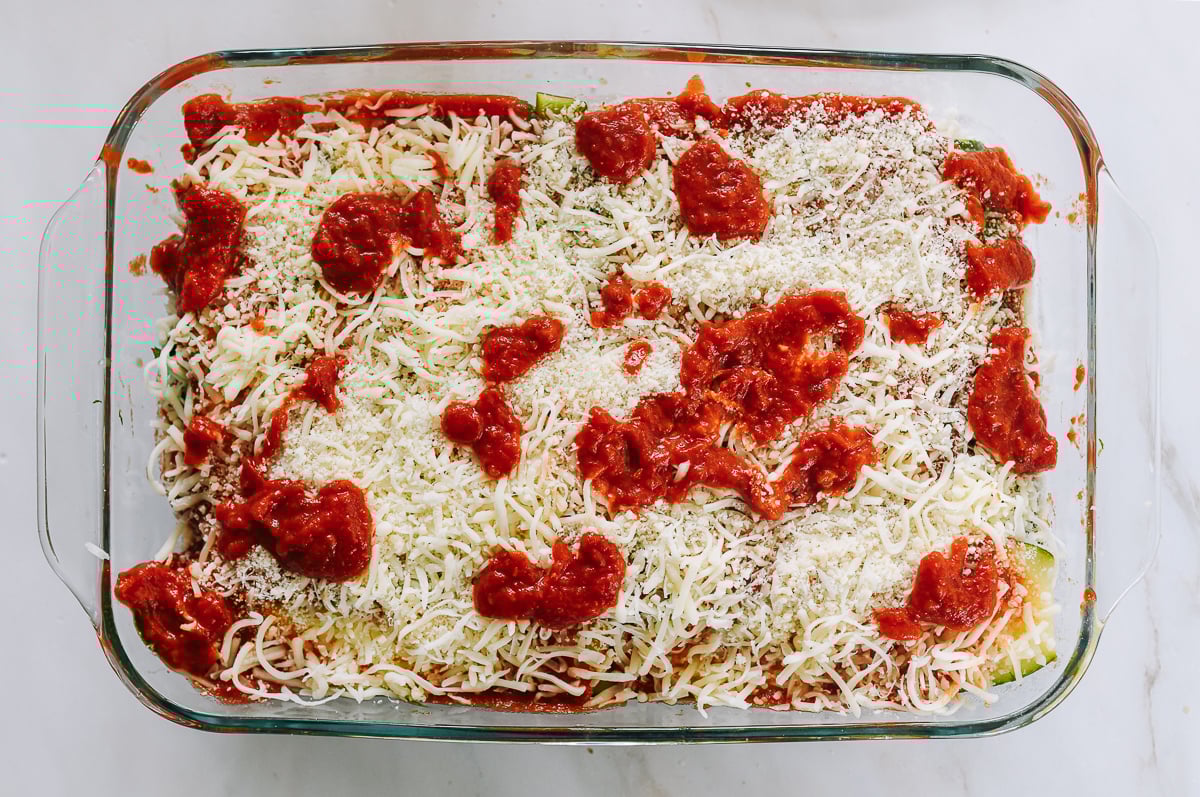 assembled lasagna in glass baking dish before baking