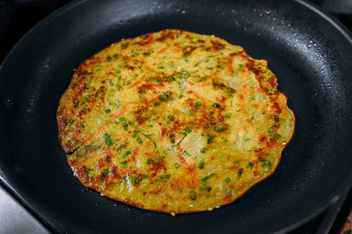 cooked vegetable pancake in frying pan