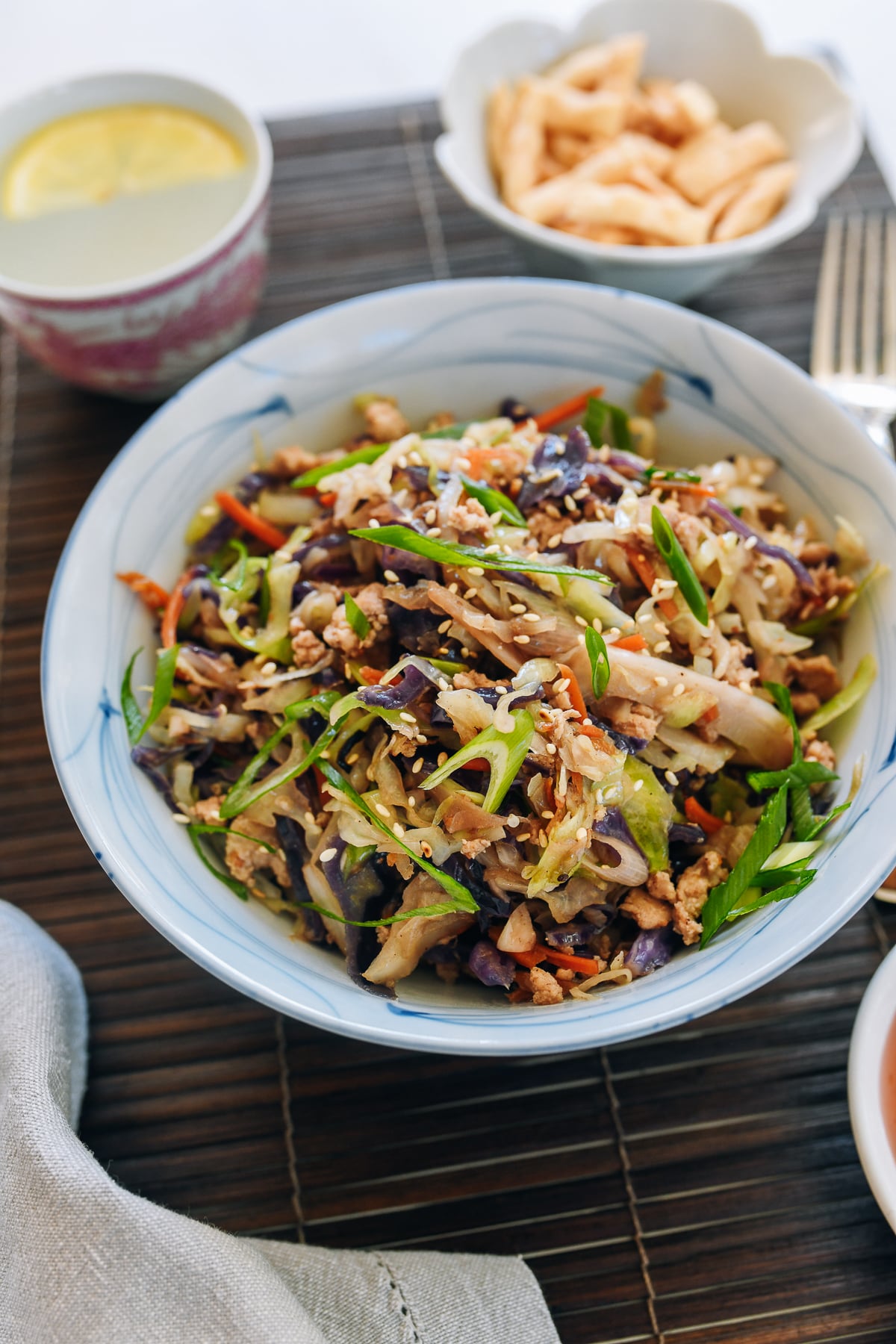 Egg Roll in a Bowl garnished with scallions and sesame seeds, served with wonton chips