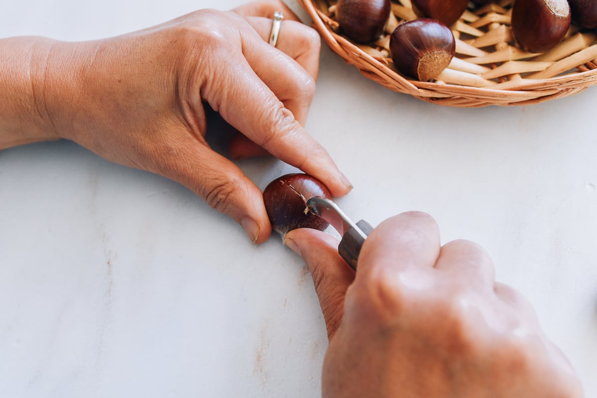 scoring X into curved side of chestnut with a chestnut knife