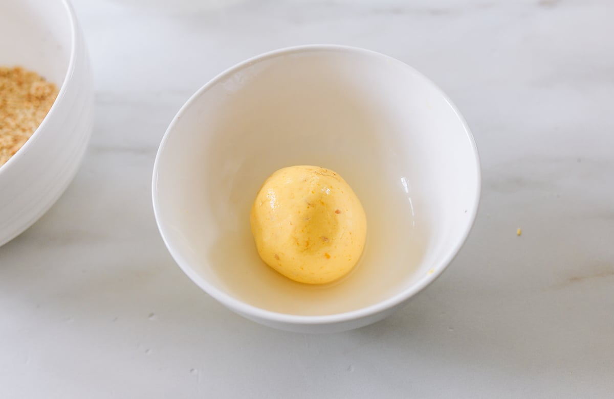 rolling pumpkin dough ball in water