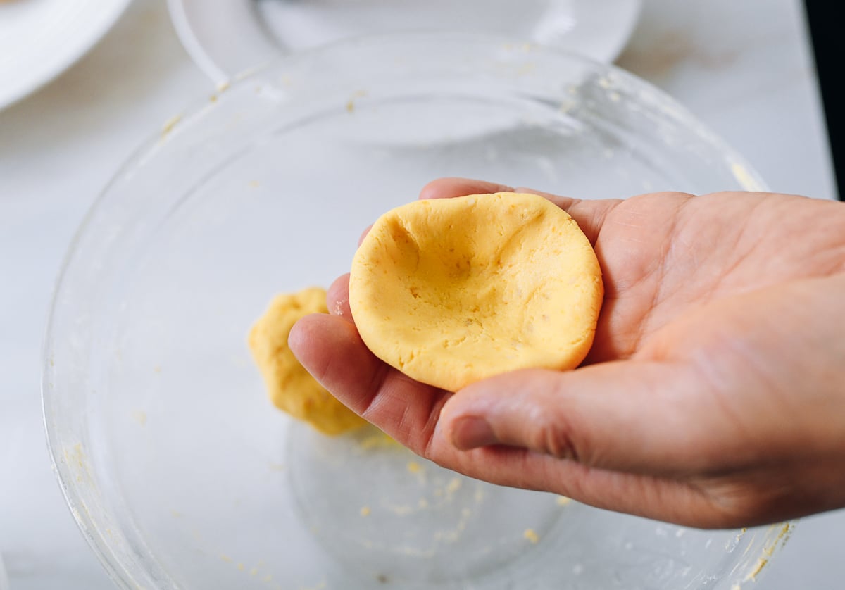 flattened pumpkin cake dough in palm