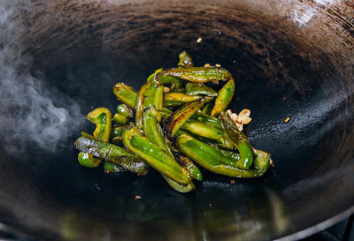 blistered green peppers in wok