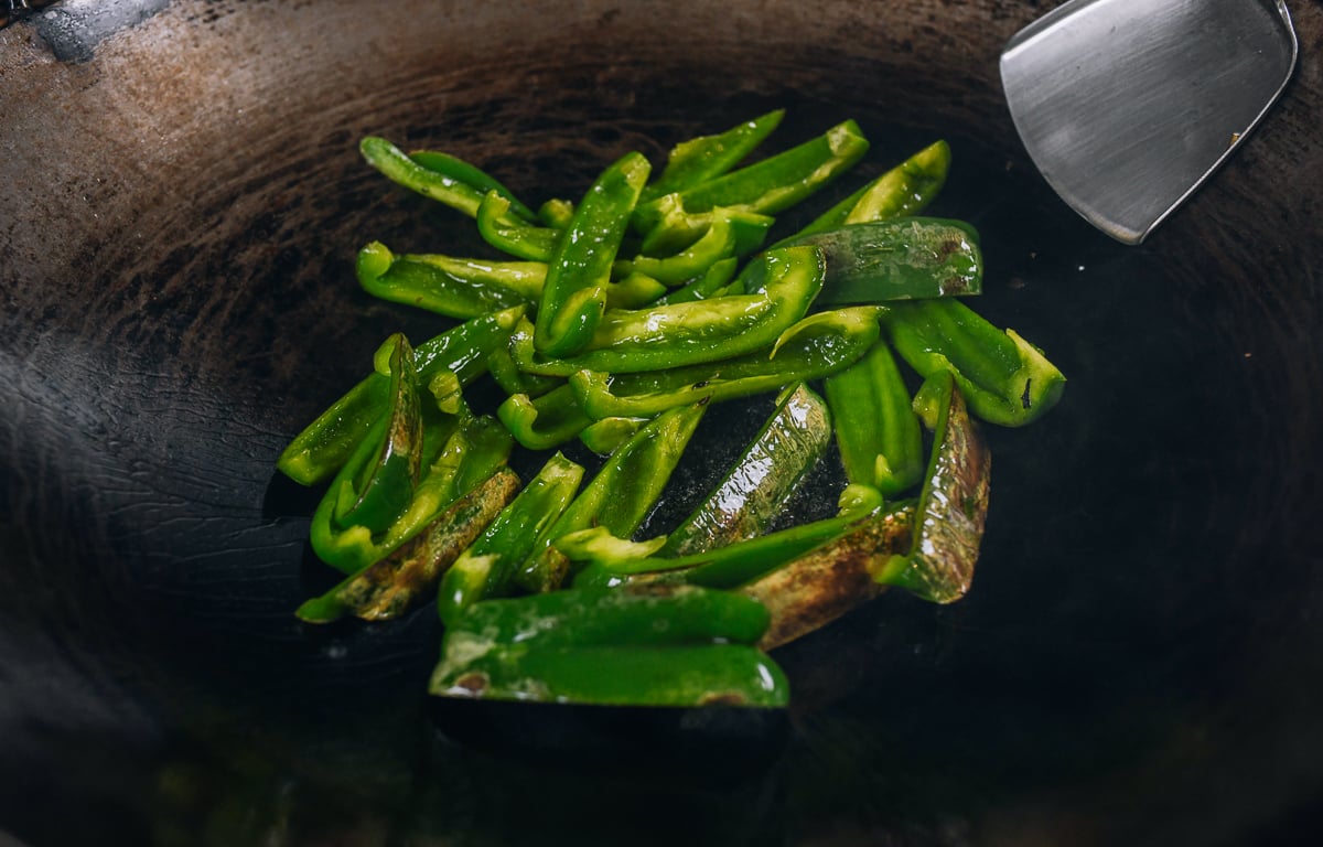 blistering green peppers in wok
