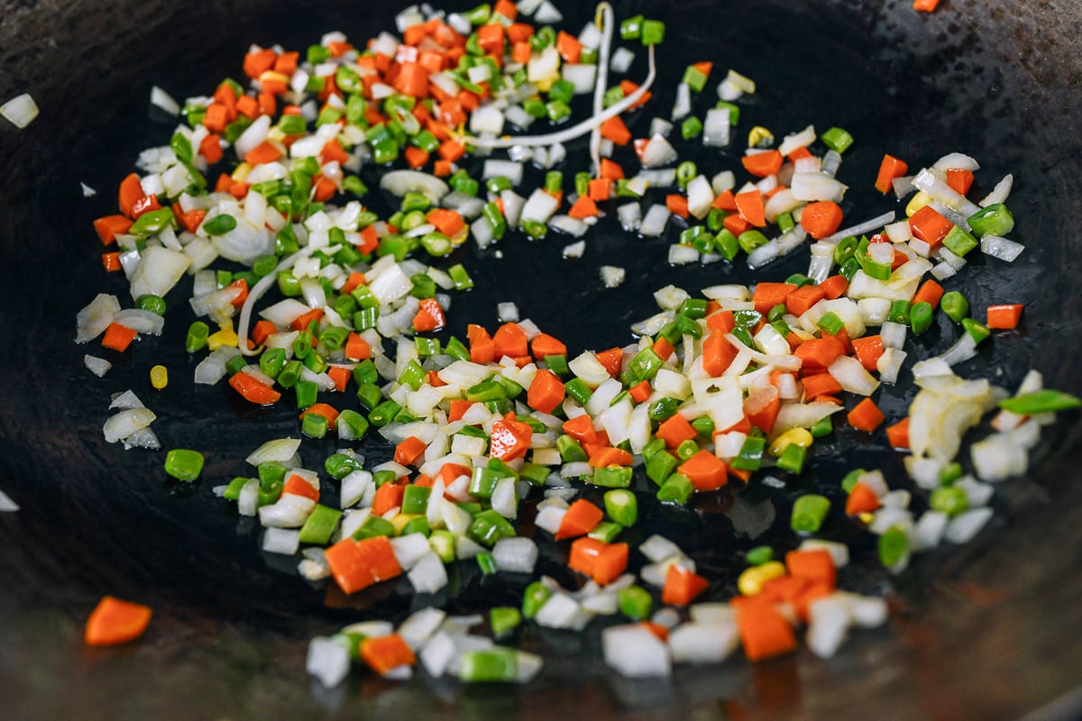 onions, carrots, and string beans in wok with oil