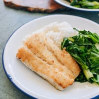 Pan-fried cod on a plate with rice and vegetables