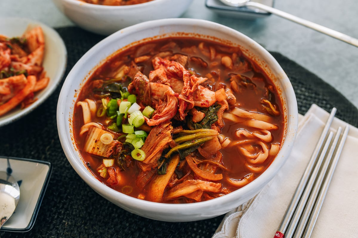 Bowl of kimchi noodle soup topped with scallions