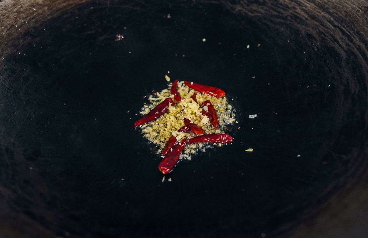 chilies and ginger in wok of oil