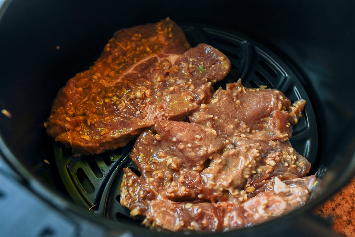vietnamese pork chops in air fryer basket before cooking