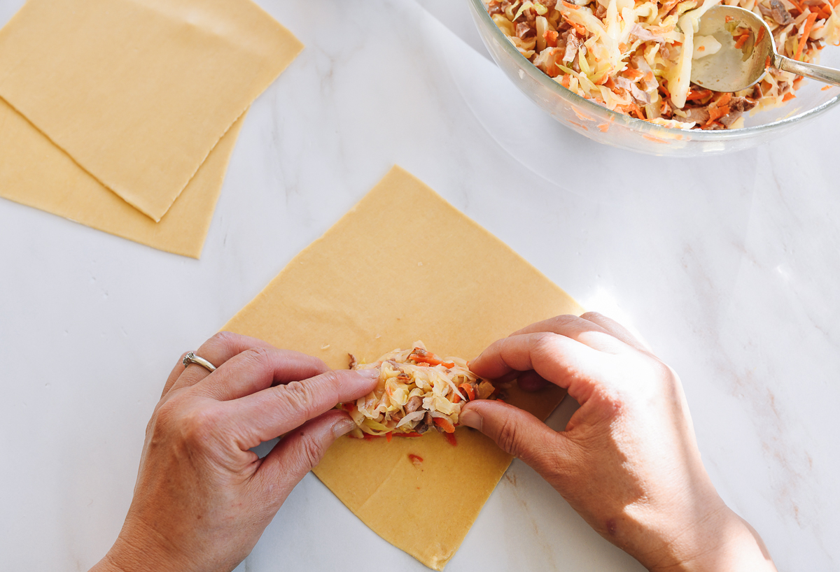 adding filling to egg roll wrapper