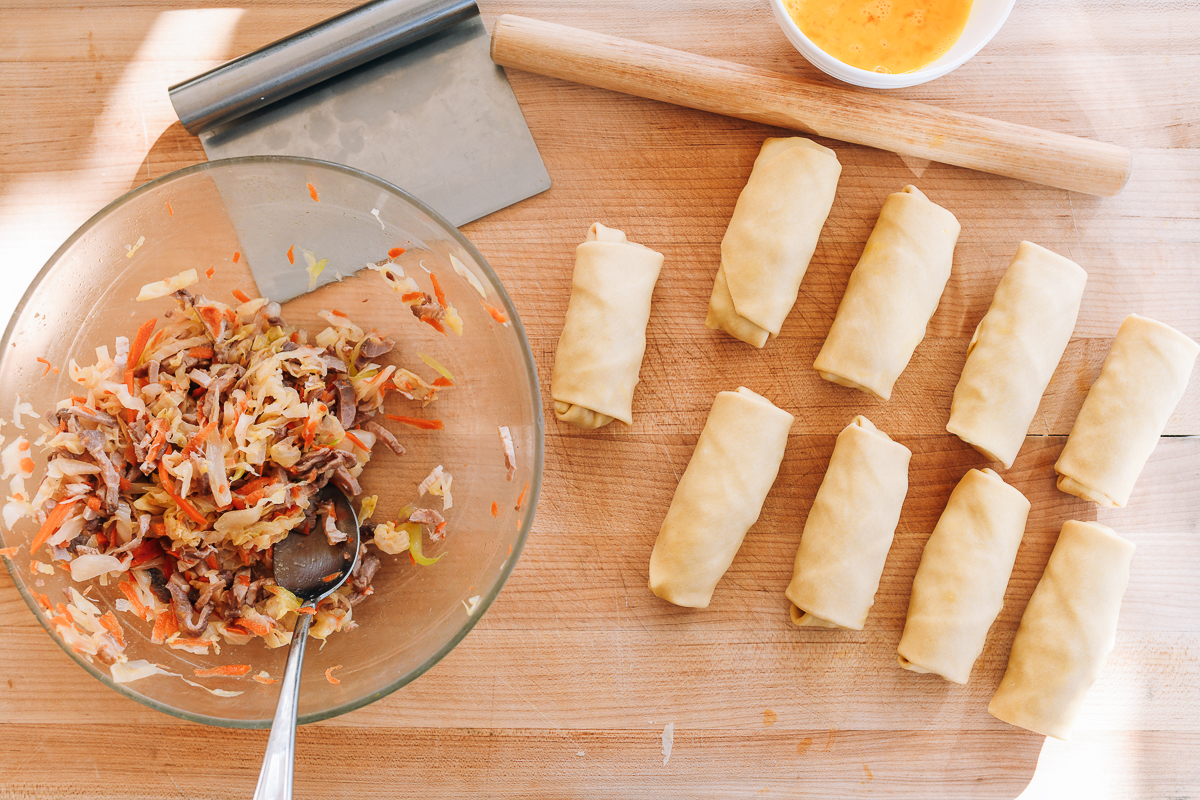 assembled egg rolls on cutting board