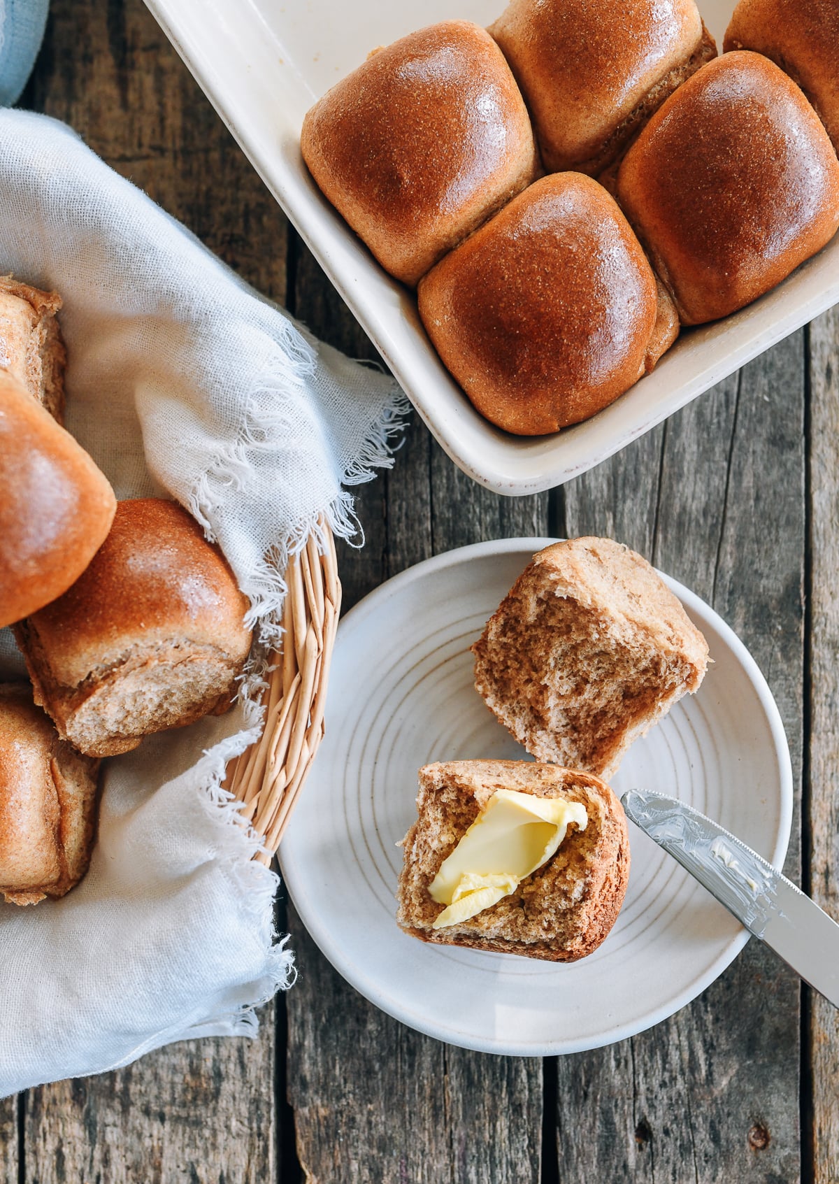 halved wheat dinner roll with butter spread on it