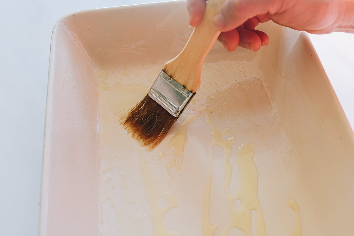 brushing baking dish with oil