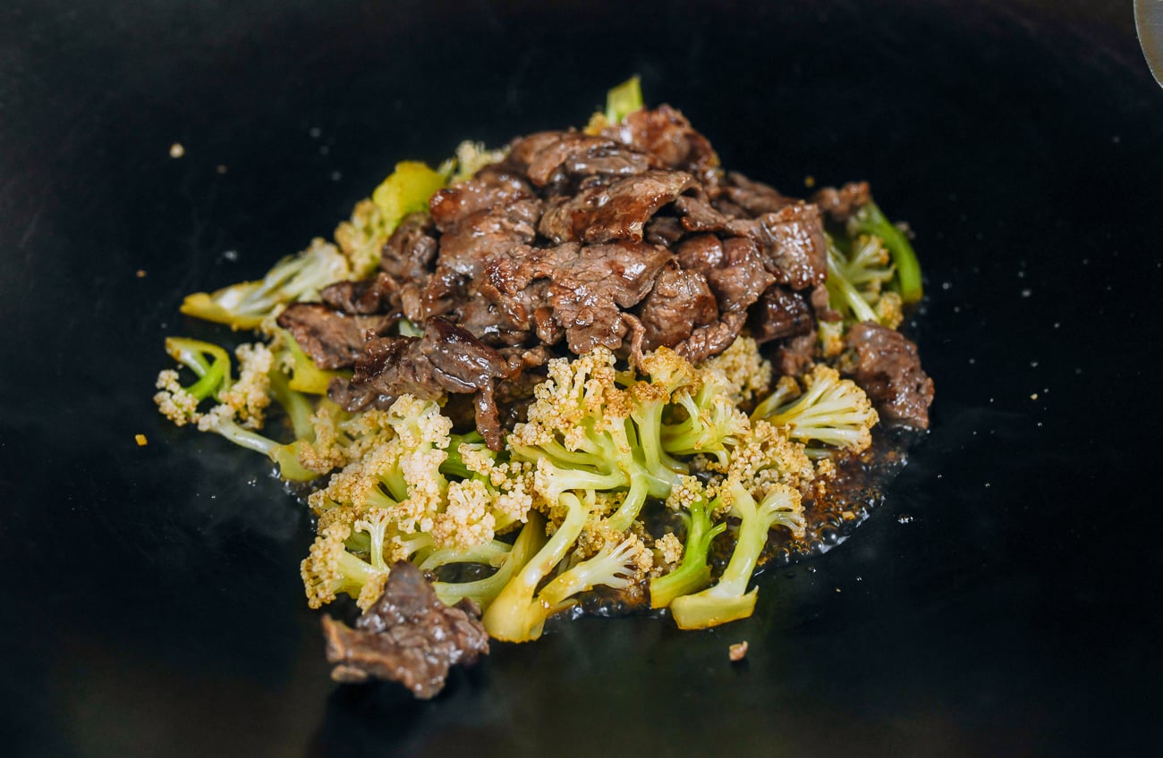 beef and cauliflower added to sauce in wok