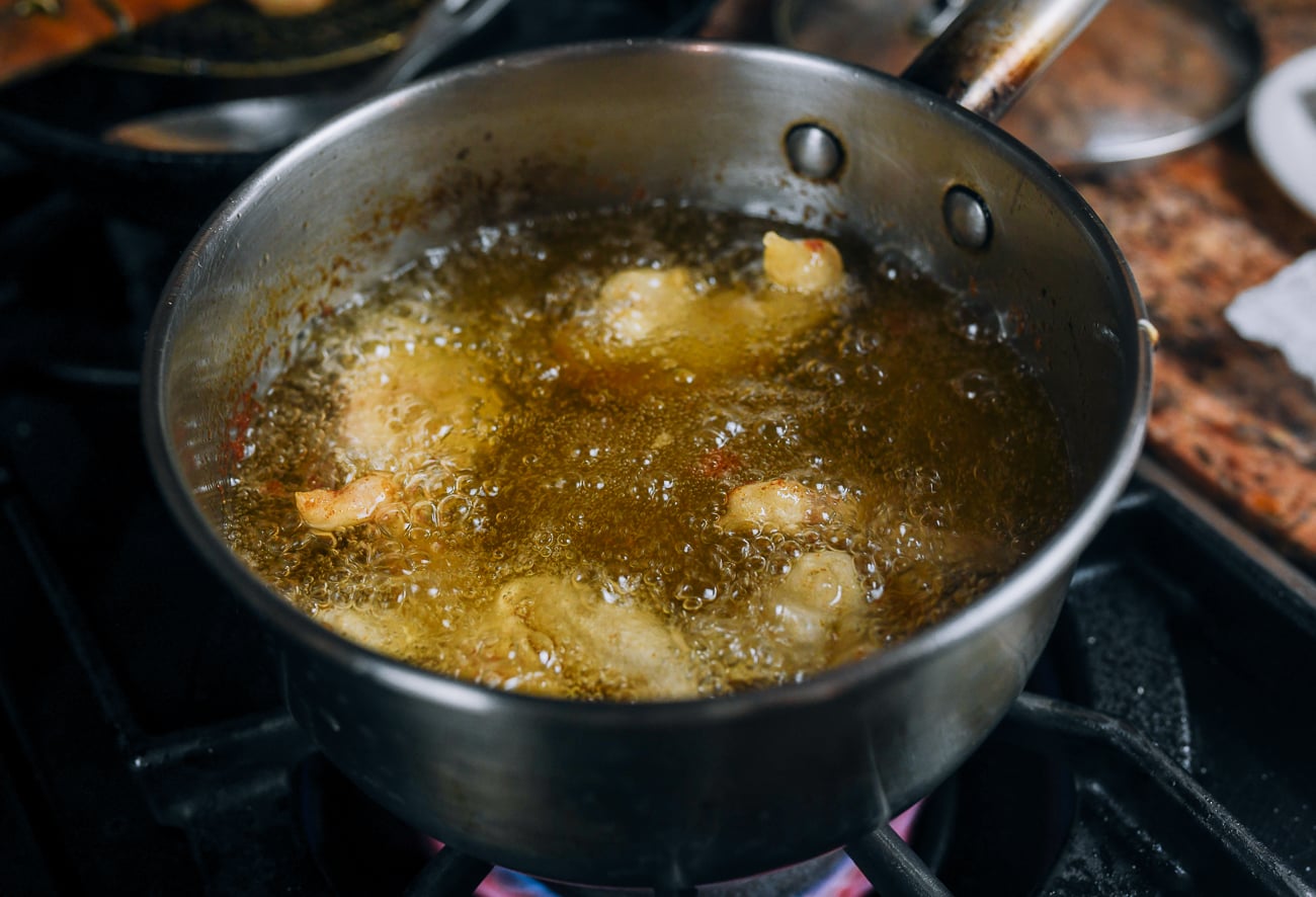 deep-frying shrimp in medium pot of oil