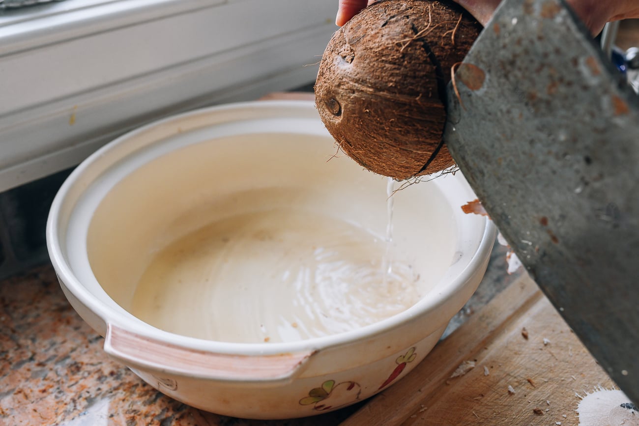 pouring coconut water from crack in mature coconut