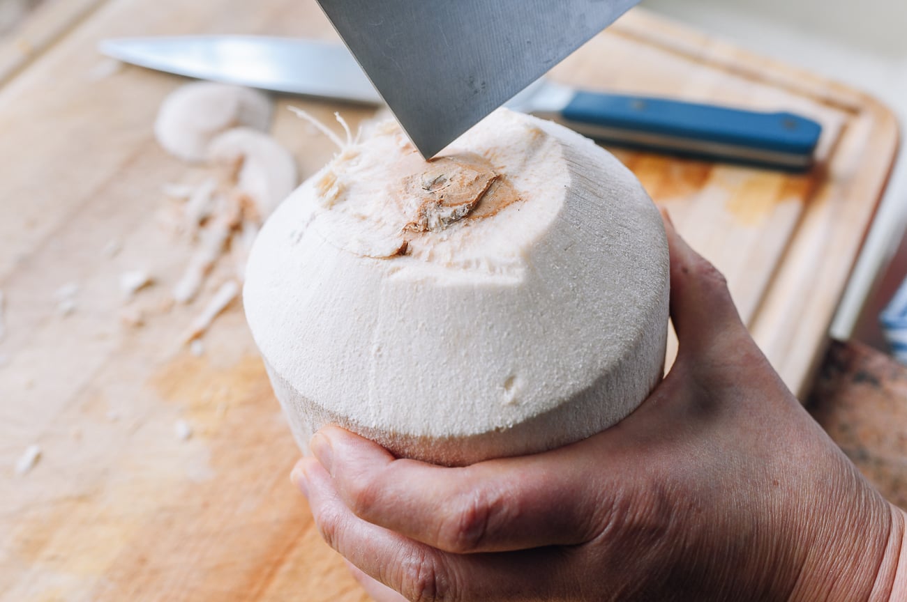 poking hole in top of young coconut