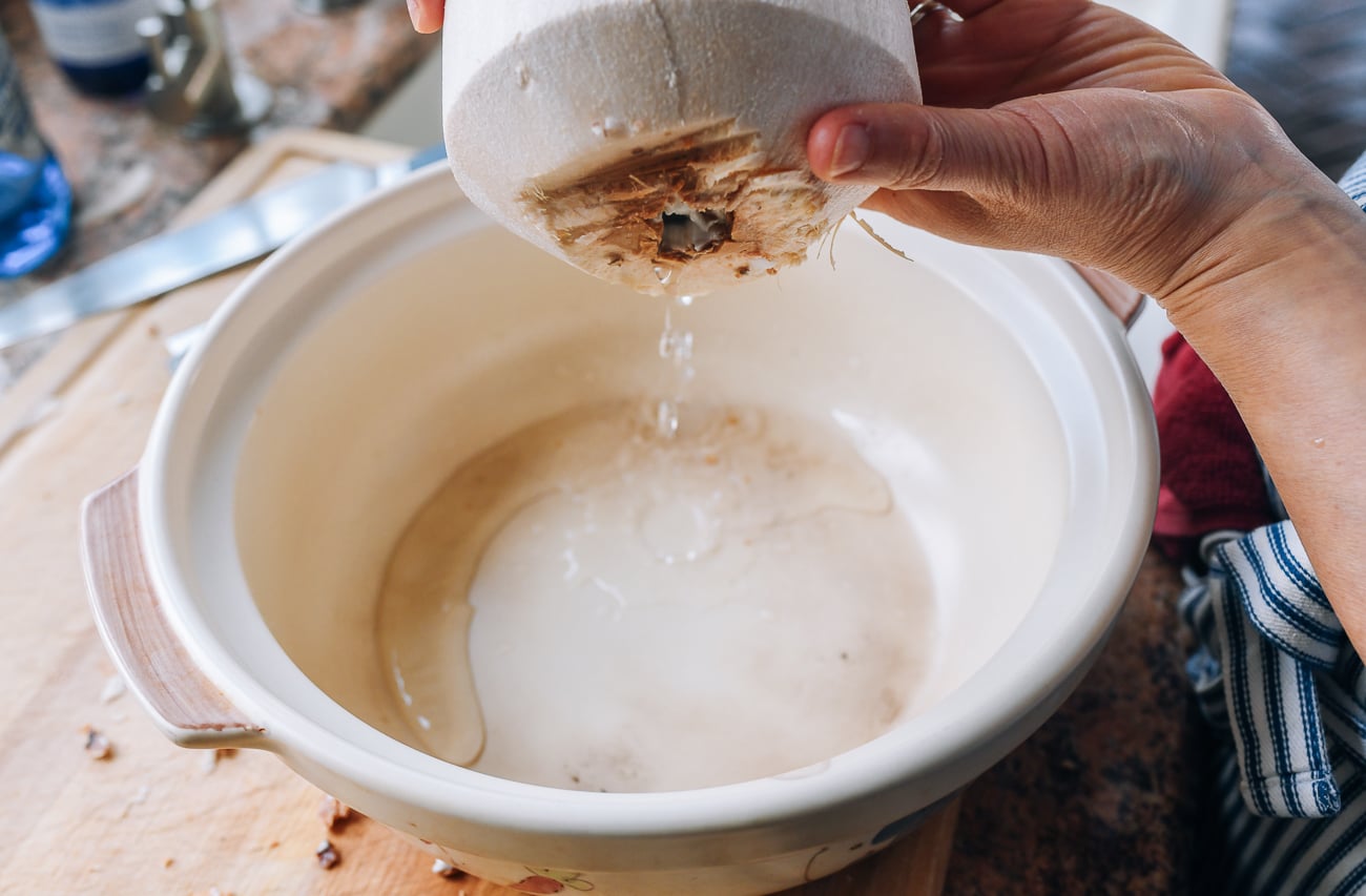 pouring water out of young coconut
