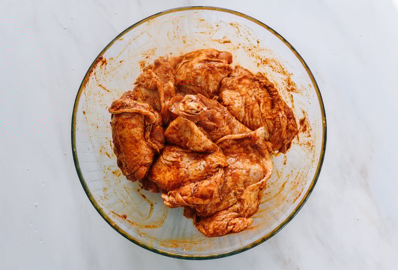marinated chicken thighs in glass bowl