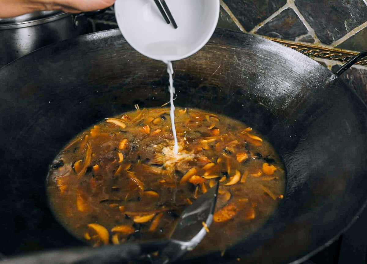pouring cornstarch slurry into da lu mian mixture