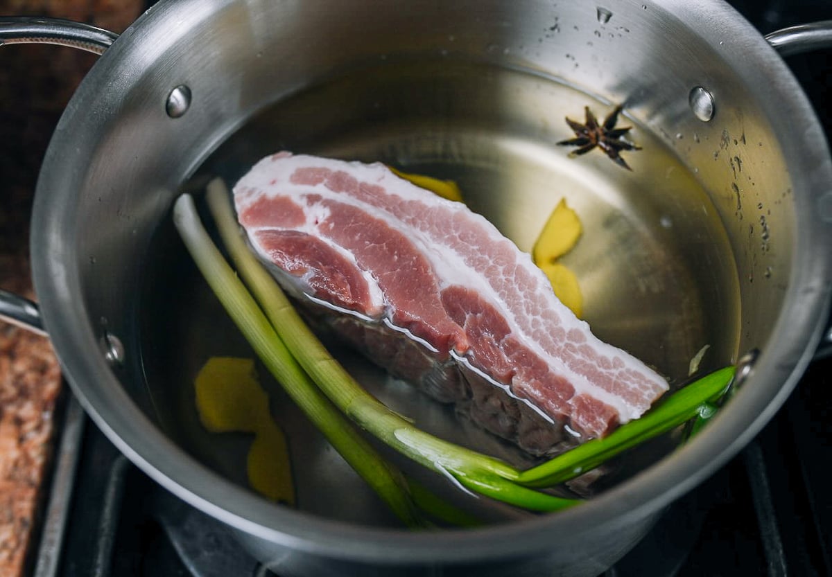 pork belly in pot with water and aromatics