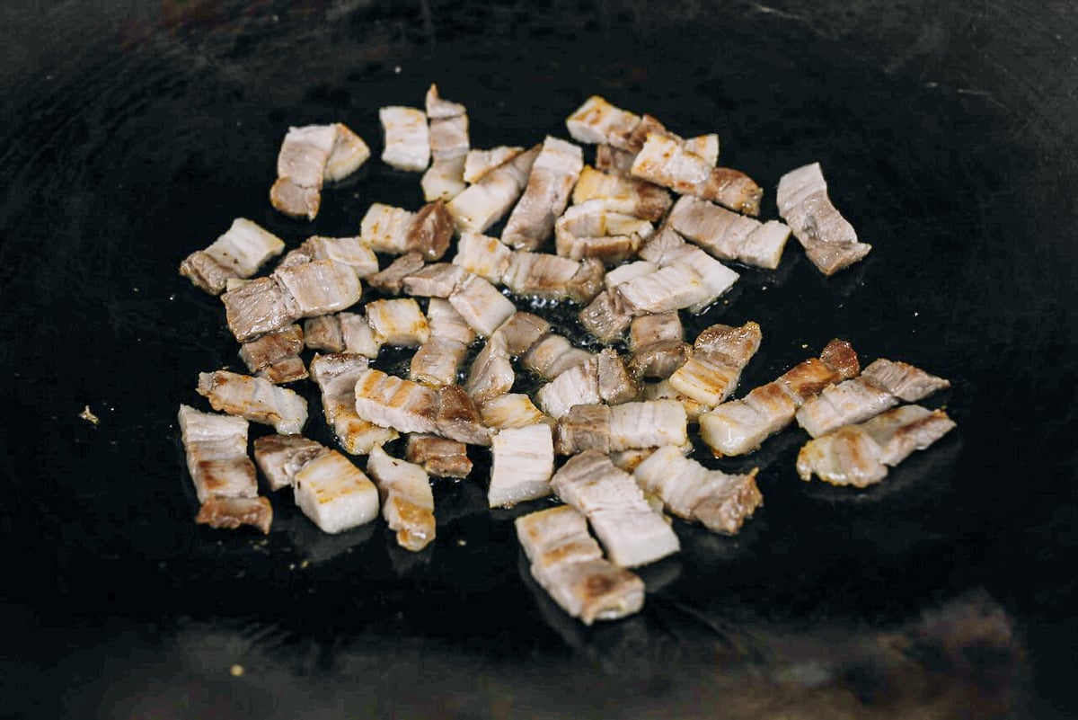 browning pork belly slices in wok