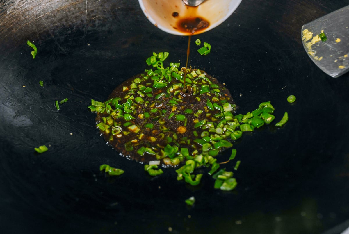 adding sauce mixture to peppers and scallions