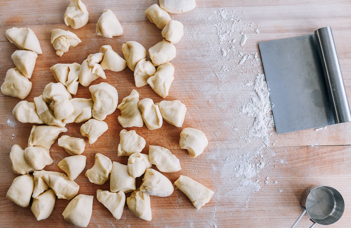 milk bread dough cut into small chunks on cutting board